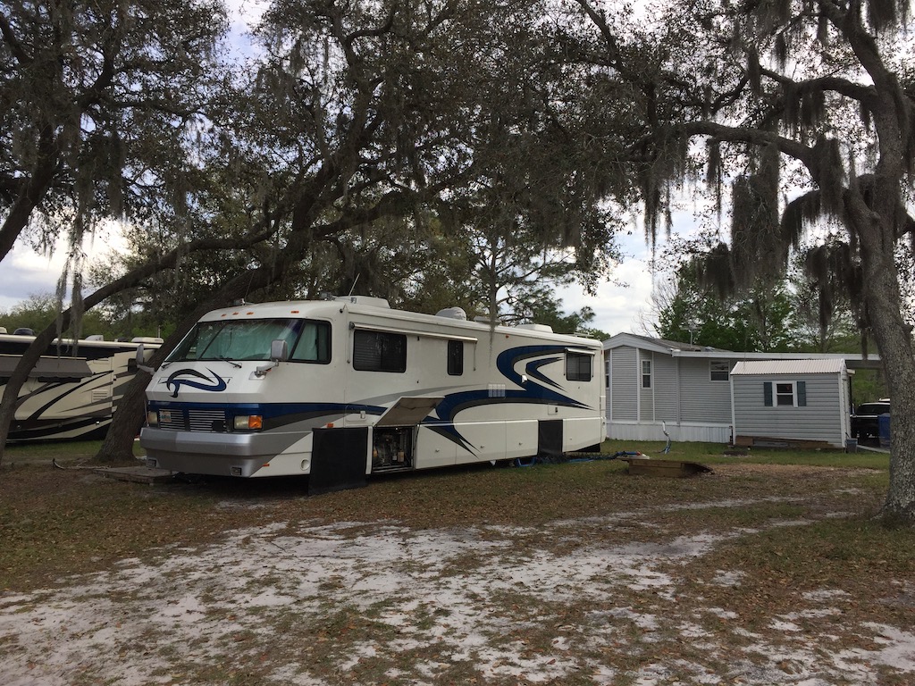 Old RV sitting under some live oaks covered with spanish moss